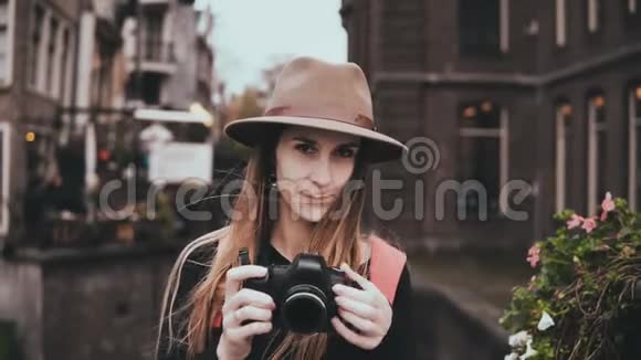 带着摄像机的快乐白人女人的肖像迷人的开朗女士戴着时尚的帽子拍照4K前景视频的预览图