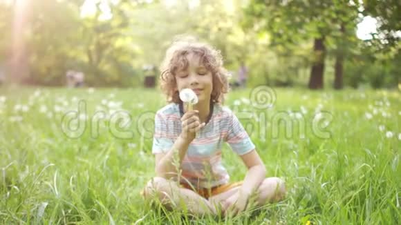 快乐的男生男孩和女孩在一个夏天的空地上玩耍他们拥抱吹着蒲公英开心地笑视频的预览图