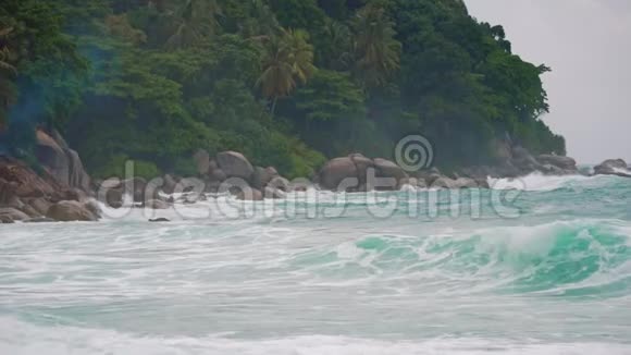 海浪拍打着热带岛屿上的岩石慢动作视频的预览图