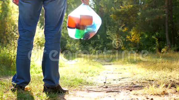 一个人站在森林空地上手里拿着一包垃圾一个垃圾收集器垃圾和自然很近视频的预览图