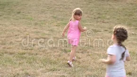 三个孩子在草地上的公园里跑步视频的预览图