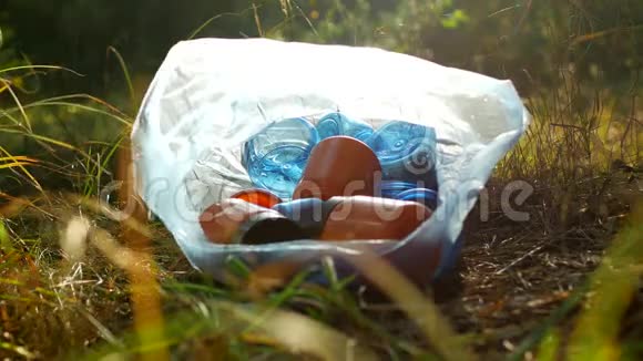垃圾装在塑料袋里塑料瓶躺在草地上对大自然垃圾和大自然的污染视频的预览图