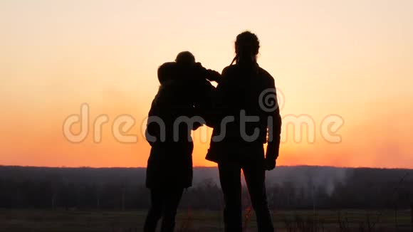 妈妈爸爸和女儿在日落背景下剪影式视频的预览图