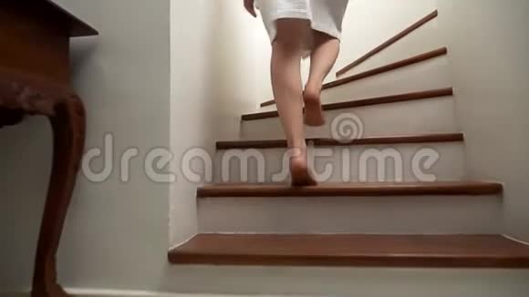 特写镜头女腿上升到木梯的顶端穿着睡衣的女人走上台阶视频的预览图