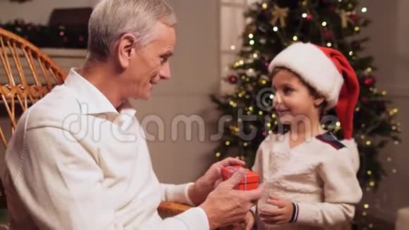 可爱的老人从他的孙子那里得到圣诞礼物视频的预览图