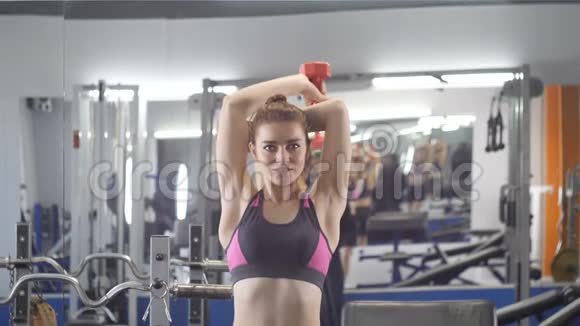运动年轻女孩在健身房做三头肌伸展运动女人手背在头上手背在前视频的预览图