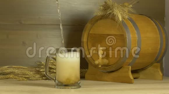 啤酒节啤酒是在一个桶和一堆小麦的背景下倒入玻璃杯中的视频的预览图