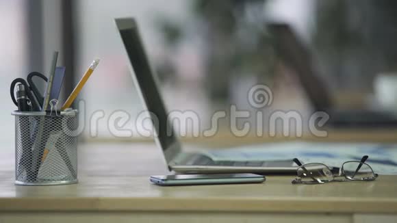 从办公桌上拿智能手机的女性手提电脑工作地点在公司办公室视频的预览图
