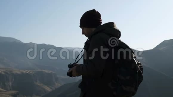 带相机拍摄高山照片的旅行者视频的预览图