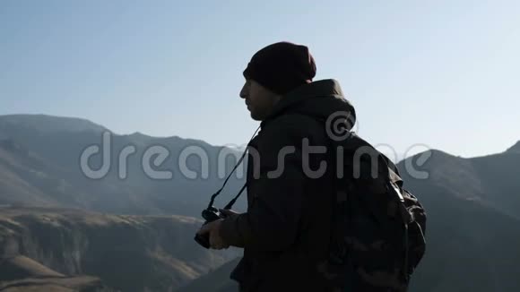 带相机拍摄高山照片的旅行者视频的预览图