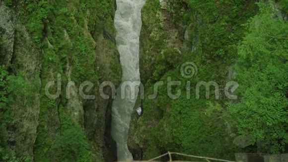 山河在狭窄的深谷中覆盖着绿色的岩石之间视频的预览图