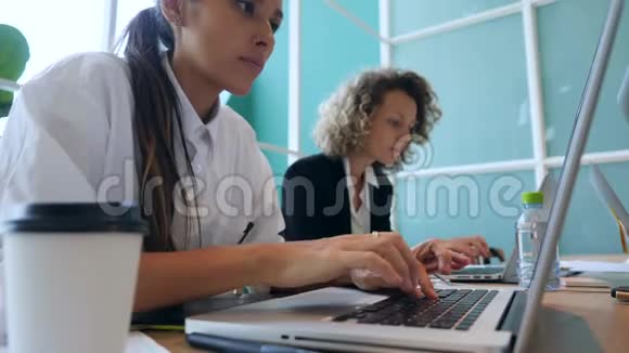有吸引力的年轻混合种族女孩在办公室工作和打字笔记本电脑4K视频的预览图