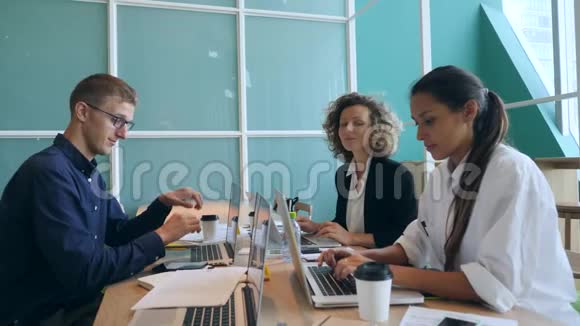 一群年轻的混合种族商人在办公室里展示大拇指启动共同工作概念4K慢动作视频的预览图