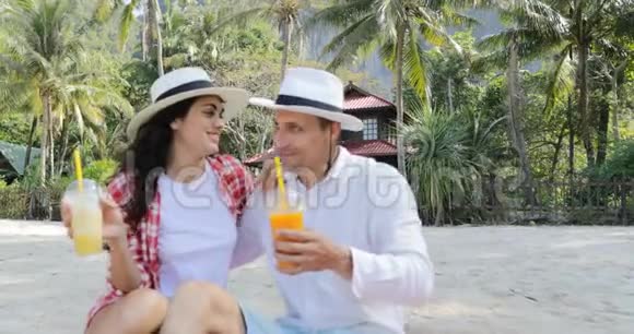 沙滩情侣谈酒汁坐拥棕榈树下欢乐男女旅游交流视频的预览图
