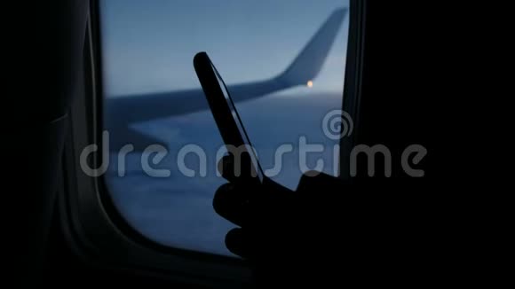 使用智能手机在飞机上用手机拨一条信息靠飞机中舷窗视频的预览图