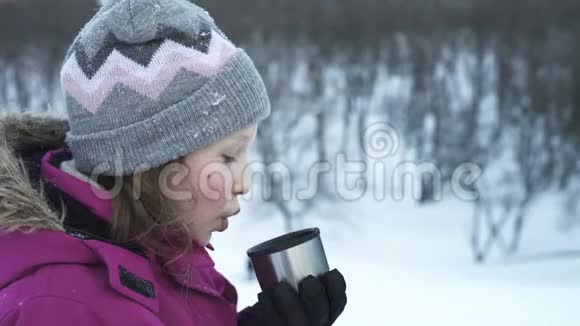 冬天在户外喝热饮料的小女孩视频的预览图