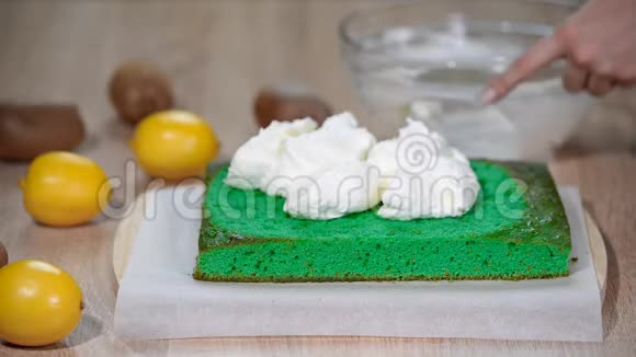把马斯卡彭奶油放在绿色海绵蛋糕上视频的预览图