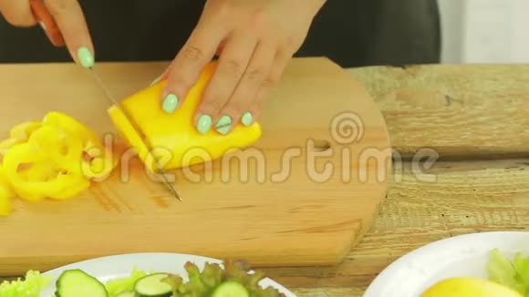 一个女人手里拿着一把刀把黄椒切成沙拉片视频的预览图