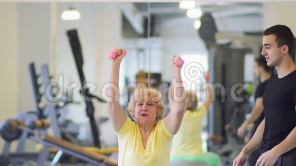 老年妇女在健身房用哑铃做运动视频的预览图