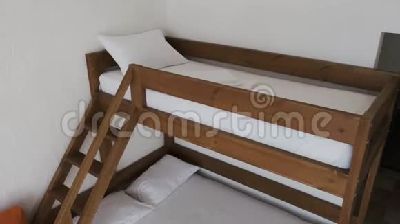 酒店客房内有一张两层床床上有白色干净的床单和枕头视频的预览图