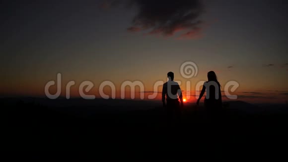 浪漫的户外肖像夫妇的剪影互相握手拥抱和亲吻在日落视频的预览图