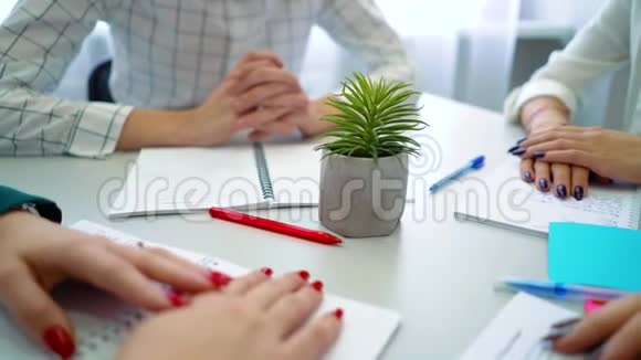 特写男生和女生桌上有笔和笔记本的手视频的预览图