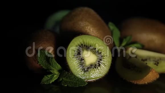美味多汁的水果猕猴桃和薄荷放在黑桌上从桌子上反射猕猴桃几维鸟的碎片视频的预览图