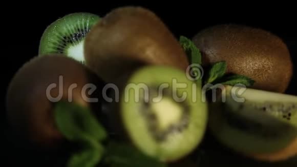美味美丽的水果猕猴桃和薄荷躺在黑桌上从桌子上反射猕猴桃高清特写视频的预览图