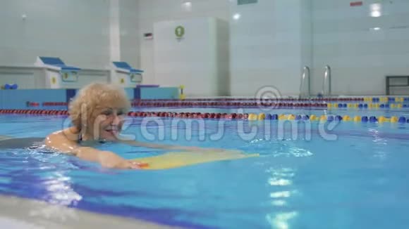 老年妇女带着特殊设备在游泳池游泳视频的预览图