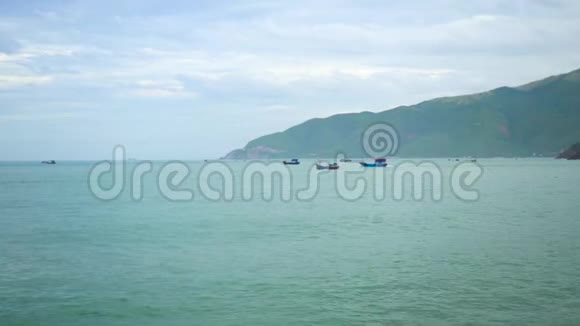 在青山背景下在海上航行的渔船在蓝色海洋航行的船美丽的绿松石海视频的预览图