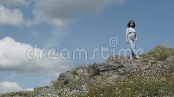 女孩走在岩石坡上视频的预览图