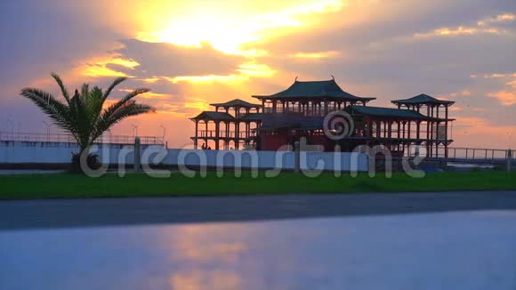 棕榈树和中国房子背景下美丽的日落视频的预览图