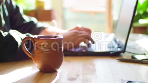 有笔记本电脑的咖啡馆里的男人关注热茶这一杯人端茶喝只有没有脸的手视频的预览图