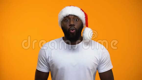 带圣诞帽圣诞魔术黄色背景的美国黑人男子视频的预览图