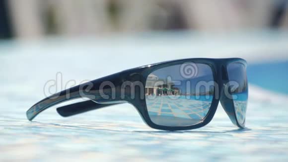海滩上有蓝色海洋背景的太阳镜夏天侧视选择性聚焦旅行者梦想的概念视频的预览图