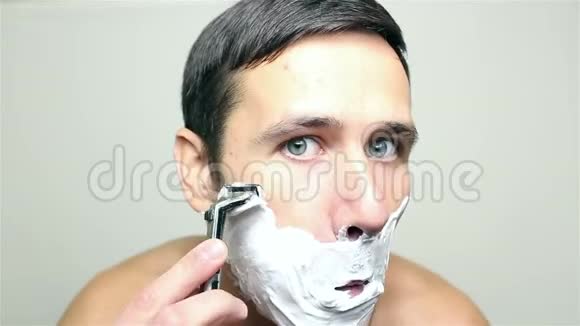 年轻的帅哥用剃刀刮脸视频的预览图