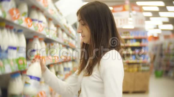 在杂货店买牛奶的年轻女子视频的预览图