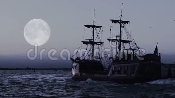 幽灵般的海盗船在无尽的蓝色海洋中驶向地平线天空中的月亮视频的预览图