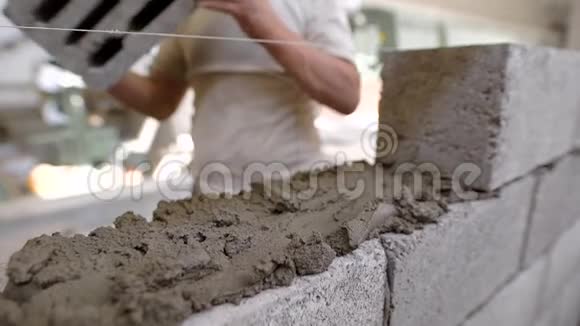 建筑工人用一根拉伸的绳子把砖放砖匠的手中用一根细绳把砖放到一个均匀的水平上视频的预览图