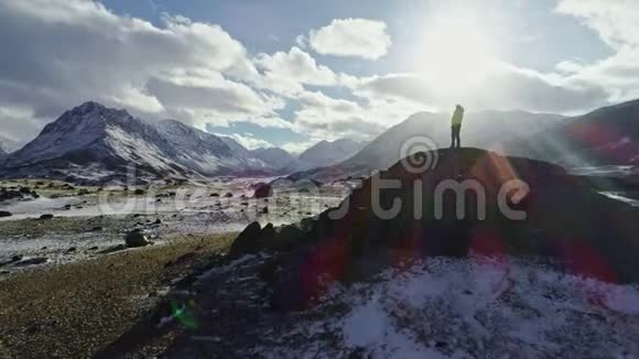 背包客走向岩石峰的边缘欣赏美丽的全景的剪影视频的预览图