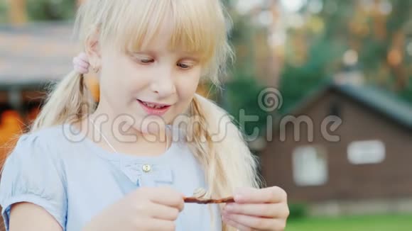 一个6岁的女孩看着手中的一只小蜗牛概念与自然交流我们周围的生活视频的预览图