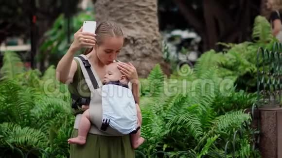 年轻的母亲带着智能手机和婴儿旅行视频的预览图