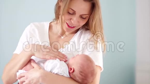 一个新生婴儿在母亲怀里妈妈和她的孩子母亲节慢动作的产妇家庭观念慢慢视频的预览图
