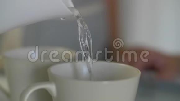 早餐全家人喝茶吃甜点手把水倒在杯子里水壶里的水被倒进杯子里视频的预览图
