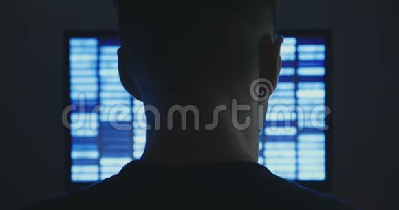 男性黑客在黑暗的办公室里的显示屏上使用二进制代码的计算机视频的预览图