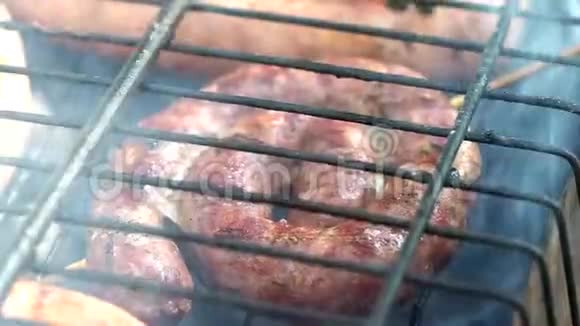 在篝火旁的烤架上烤香肠特写视频宏观的视频的预览图