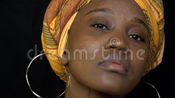 漂亮的非洲女人穿着国服戴着金色耳环看着镜头慢动作视频的预览图