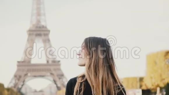 法国巴黎埃菲尔铁塔附近站着的年轻漂亮女人的肖像看着相机微笑着视频的预览图