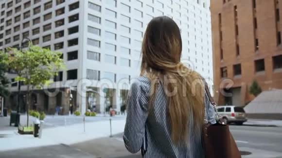 阳光明媚的日子里年轻成功的女商人在金融区工作慢动作视频的预览图