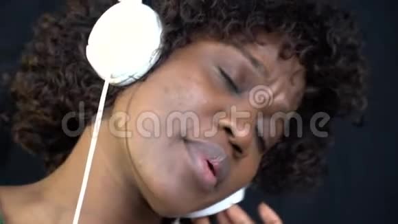 一位戴着耳机的黑人女子唱着慢动作视频的预览图